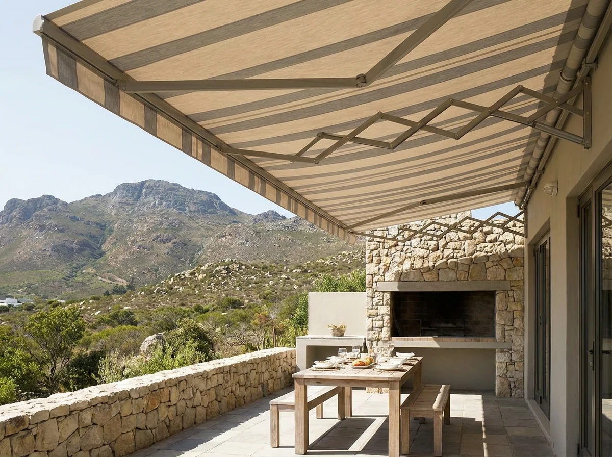 Folding-arm awning shading a braai and dining patio in a Somerset West home, Helderberg mountains beyond